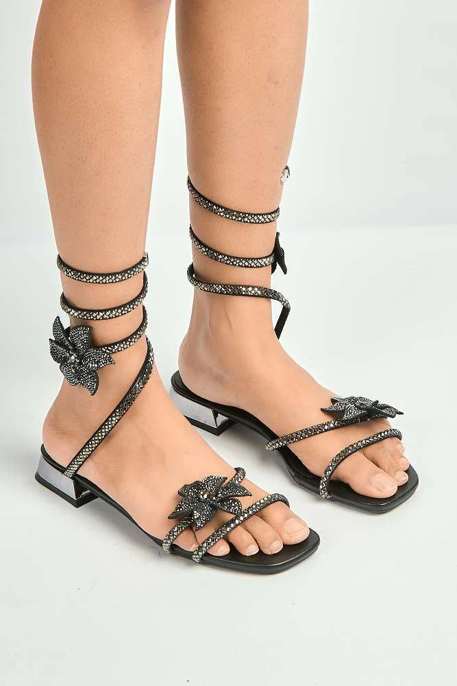 Tansel Diamante Flower Embellished Wrap Around Flat Sandals in Black